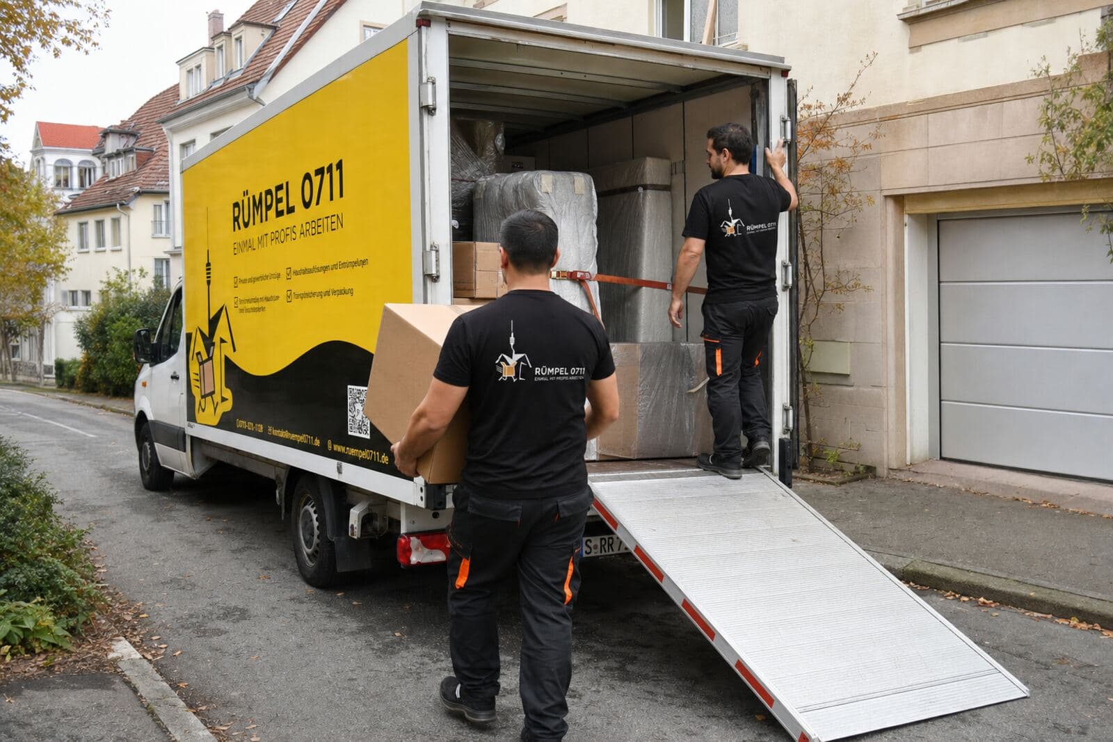 Kartons werden über die Rampe in den Rümpel 0711 Transporter geladen